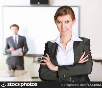 young and attractive businesswoman in an office with collegues on the background