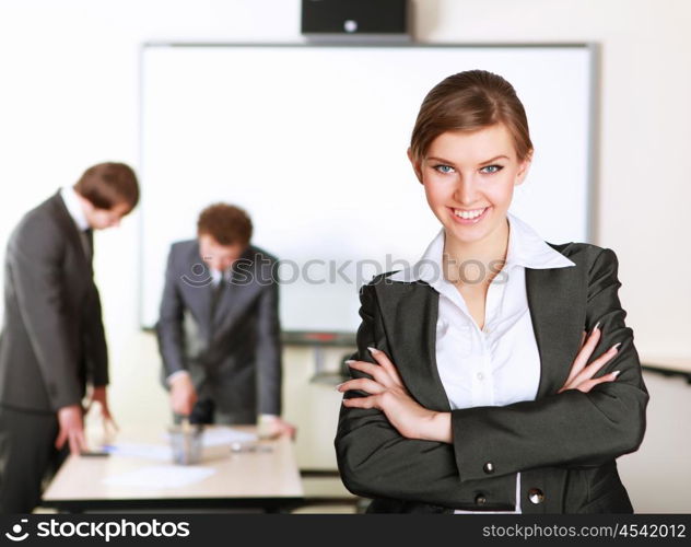 young and attractive businesswoman in an office with collegues on the background