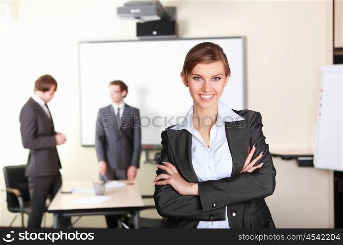 young and attractive businesswoman in an office with collegues on the background