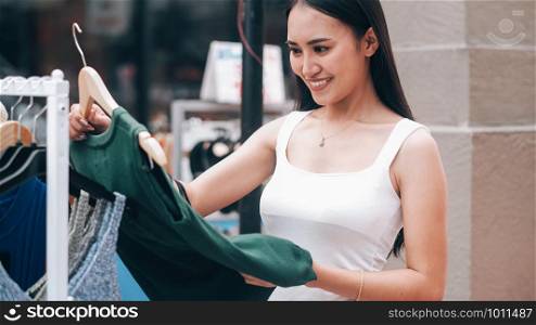 Young and attractive woman is in shopping and choosing clothes.