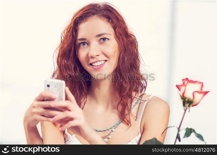 Young and attractive woman sitting in cafe and using cellphone. Texting massages at cafe