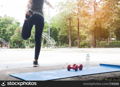 Young and attractive woman stretching before exercise in the park, Healthy lifestyle