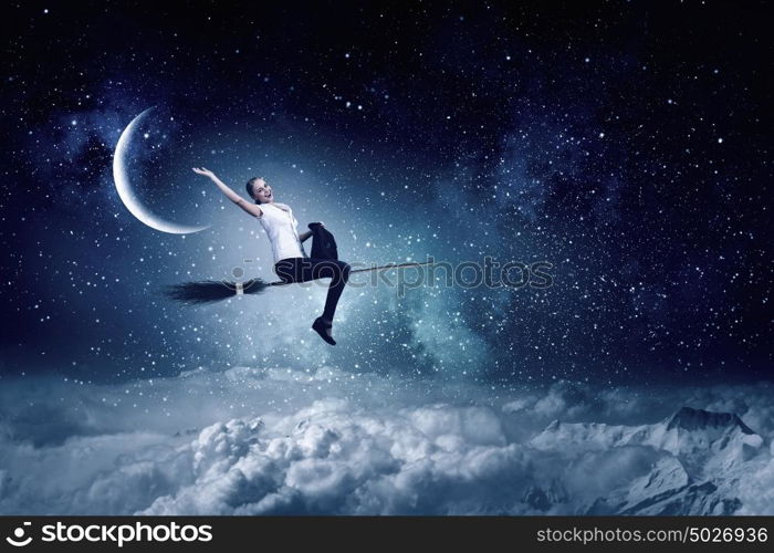 Young and careless. Happy young woman flying in sky on broom