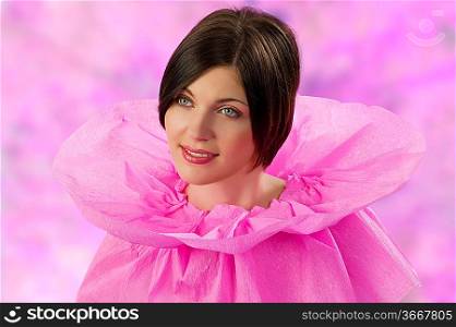 young and cute brunette in an original pink collar dress made of paper looking sweet