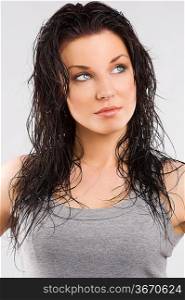 young and cute brunette wearing a gray t-shirt and taking pose with wet hair and looking up