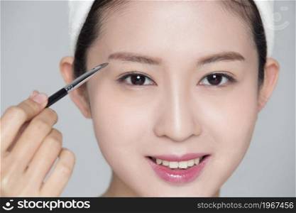 Young and elegant beauty making up