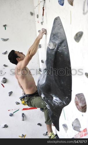 young and fit man exercise free mountain climbing on indoor practice wall