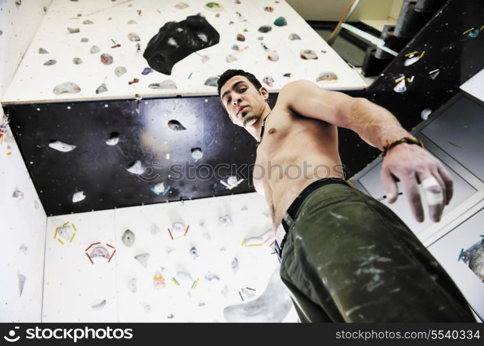 young and fit man exercise free mountain climbing on indoor practice wall