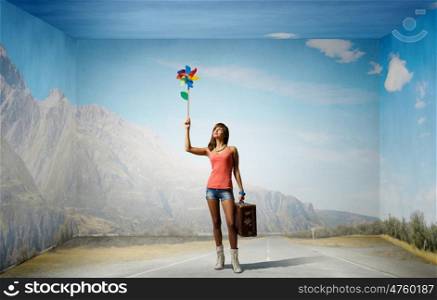 Young and happy. Happy young woman with windmill in hand