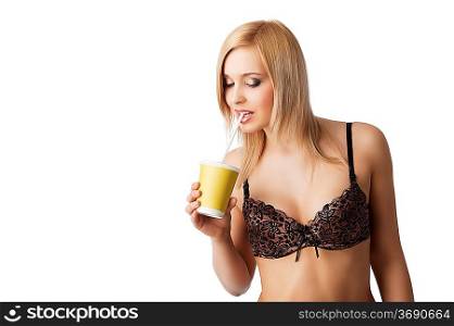young and sexy blond girl wearing brown bra and drinking from a paper cup isolated aver white, she is turned of three quarters, looks in to the lens and bites the straw