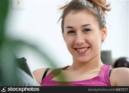 young and smiling woman using a smartphone at home