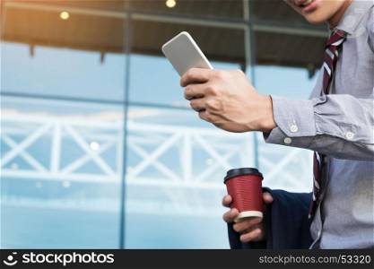 Young and successful businessman is reading a message on his smartphone.