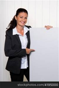 young and successful businesswoman in office with a blank panel for advertising.