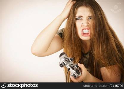 Young angry mad woman playing on the video console holding game pad. Gaming gamers concept.. Angry woman holding gaming pad