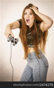 Young angry mad woman playing on the video console holding game pad. Gaming gamers concept.. Angry woman holding gaming pad
