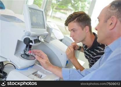 young apprentice and optician with optical instruments