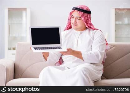 Young arab businessman working with laptop on sofa