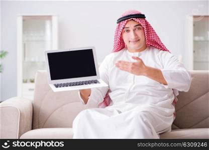 Young arab businessman working with laptop on sofa