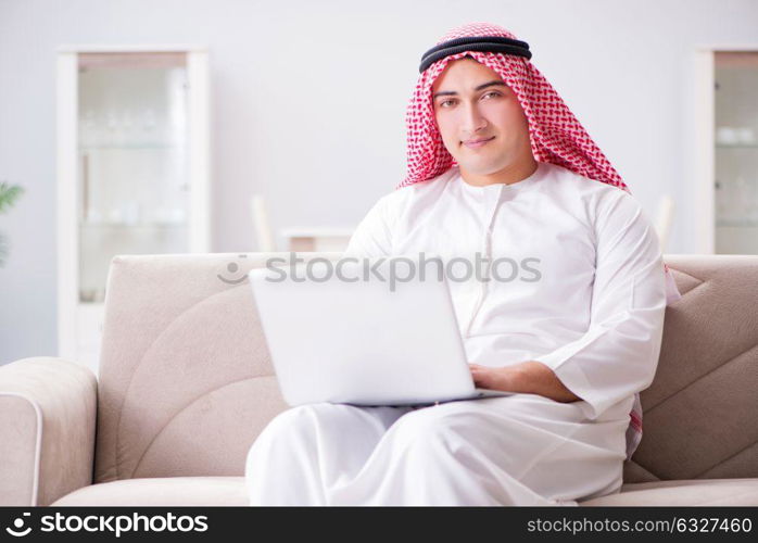 Young arab businessman working with laptop on sofa