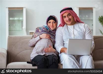 Young arab muslim family with pregnant wife expecting baby
