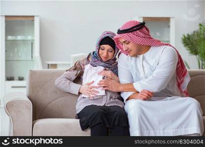 Young arab muslim family with pregnant wife expecting baby