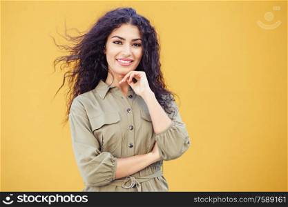 Young Arab Woman, model of fashion, with curly hair in urban background. Young Arab Woman with curly hair outdoors