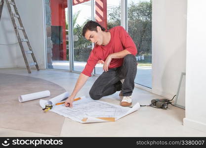 Young architect analyzing blueprint with concentration