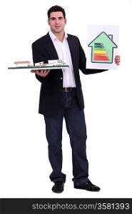 young architect holding model shows energy rating house