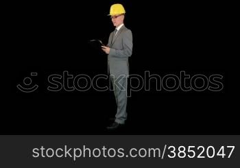 Young architect taking notes on a clipboard, against black
