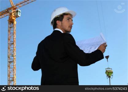 Young architect with a crane in the background
