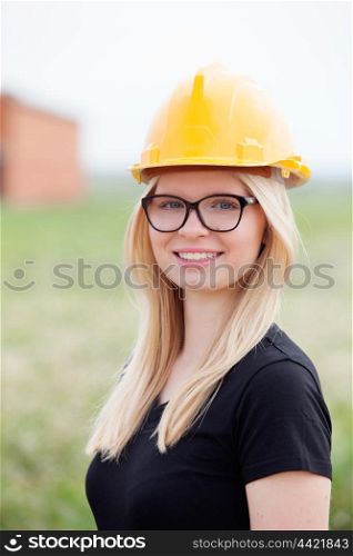 Young architect with yellow helmet near his workplace