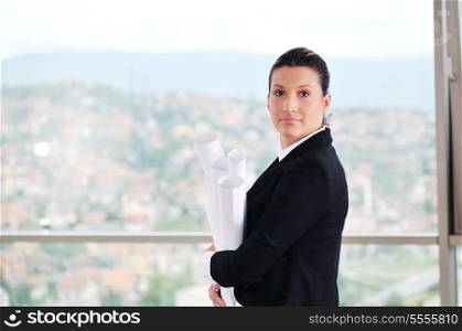 young architect woman in business suit portrait with yellow hemet and blueprints