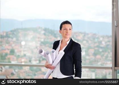 young architect woman in business suit portrait with yellow hemet and blueprints