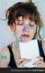 Young art student with paint in her face