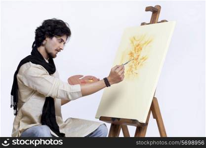 Young artist painting against white background