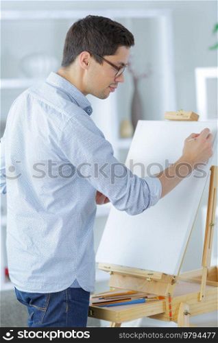 young artist with brush and palette is going to paint