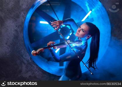 Young artistic woman performer playing violin in atmospheric studio. Neon light, futuristic industrial design. Artistic woman performer playing violin in atmospheric studio