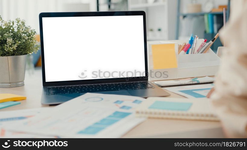 Young Asia businesswoman use smart phone with blank white screen mock up display for advertising text while smart working from home at living room. Chroma key technology, Marketing design concept.