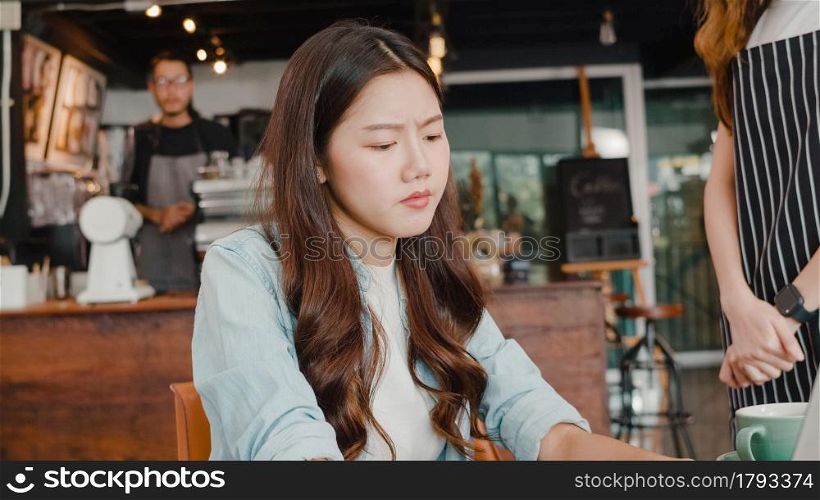 Young Asia freelance lady client talk dispute with millennial waitress feel dissatisfied with cafe bad service, mad disappointed customers speak with staff complain about wrong order coffee shop.