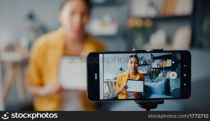 Young Asia lady teacher video call on smartphone talk by webcam learn teach in online chat at home. Remote school class, Social distancing, quarantine for corona virus prevention. Close up screen.