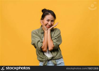 Young Asia lady with positive expression, smile broadly, dressed in casual clothing and looking at camera over yellow background. Happy adorable glad woman rejoices success. Facial expression concept.