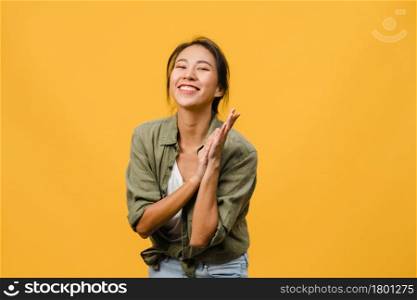 Young Asia lady with positive expression, smile broadly, dressed in casual clothing and looking at camera over yellow background. Happy adorable glad woman rejoices success. Facial expression concept.