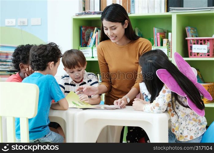 Young asia woman teacher teaching kids in kindergarten classroom, preschool education concept