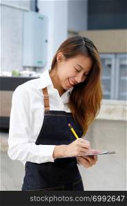 Young asian barista taking order at coffee cafe with smiling face, food and drink business concept