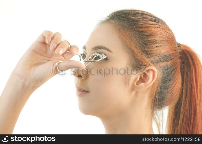 Young asian beautiful girl making her eyelashes wider with curler