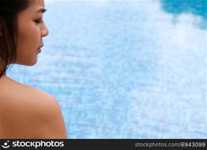 Young asian Beautiful woman relaxing in swimming pool at spa resort.