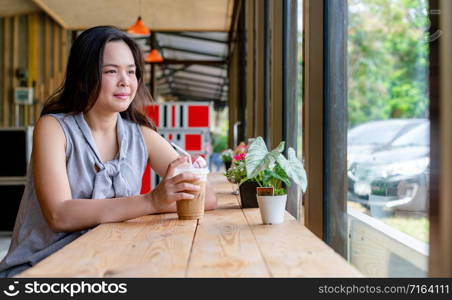 Young Asian beautiful woman sitting in a coffee shop in summer.