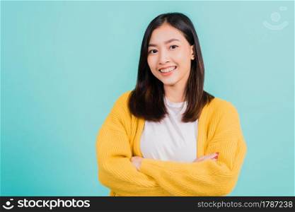 Young Asian beautiful woman smiling wear silicone orthodontic retainers on teeth with crossed arms, studio isolated on blue background, retaining tools after removable braces. Dental hygiene concept