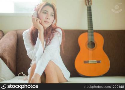 Young asian beautiful woman with smart phone and listening to music