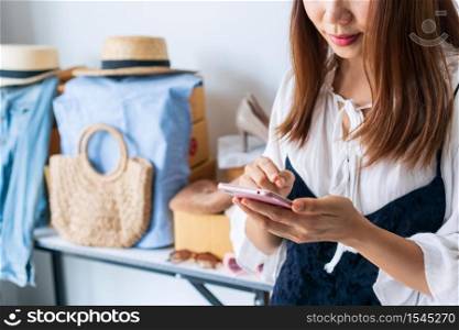 Young Asian business entrepreneur chatting with customer via smartphone. Online selling, e-commerce, business and technology, shipping, new normal concept